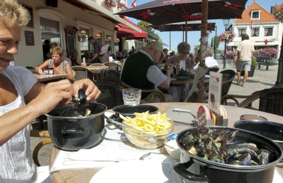 Mensen die mosselen eten op een terras